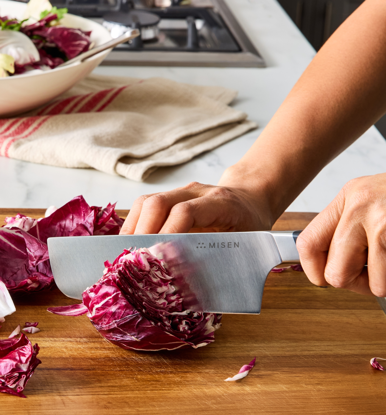 Misen chef knife slicing radicchio on a wooden cutting board